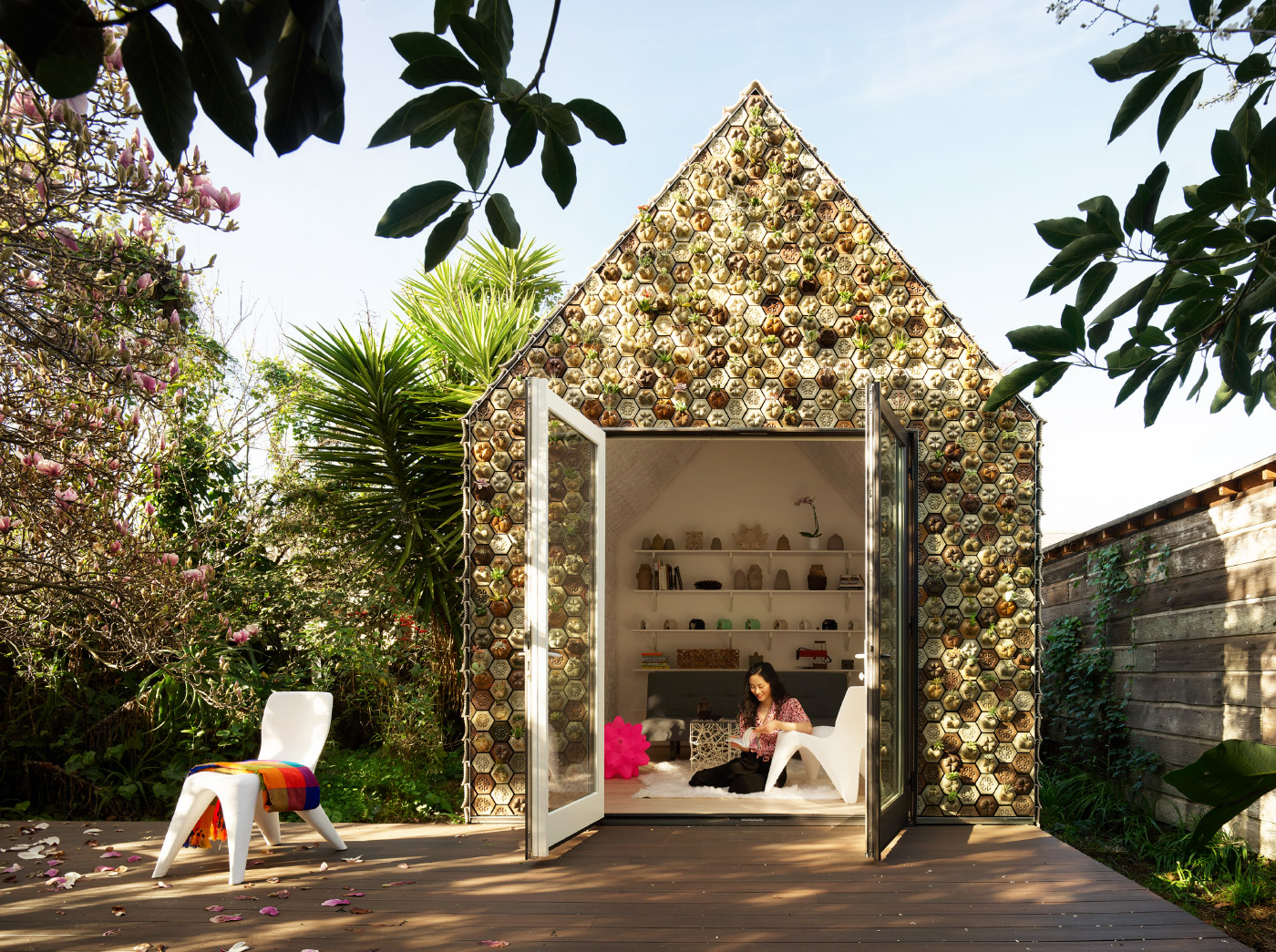 A gabled cabin covered in 3D printed plant pots