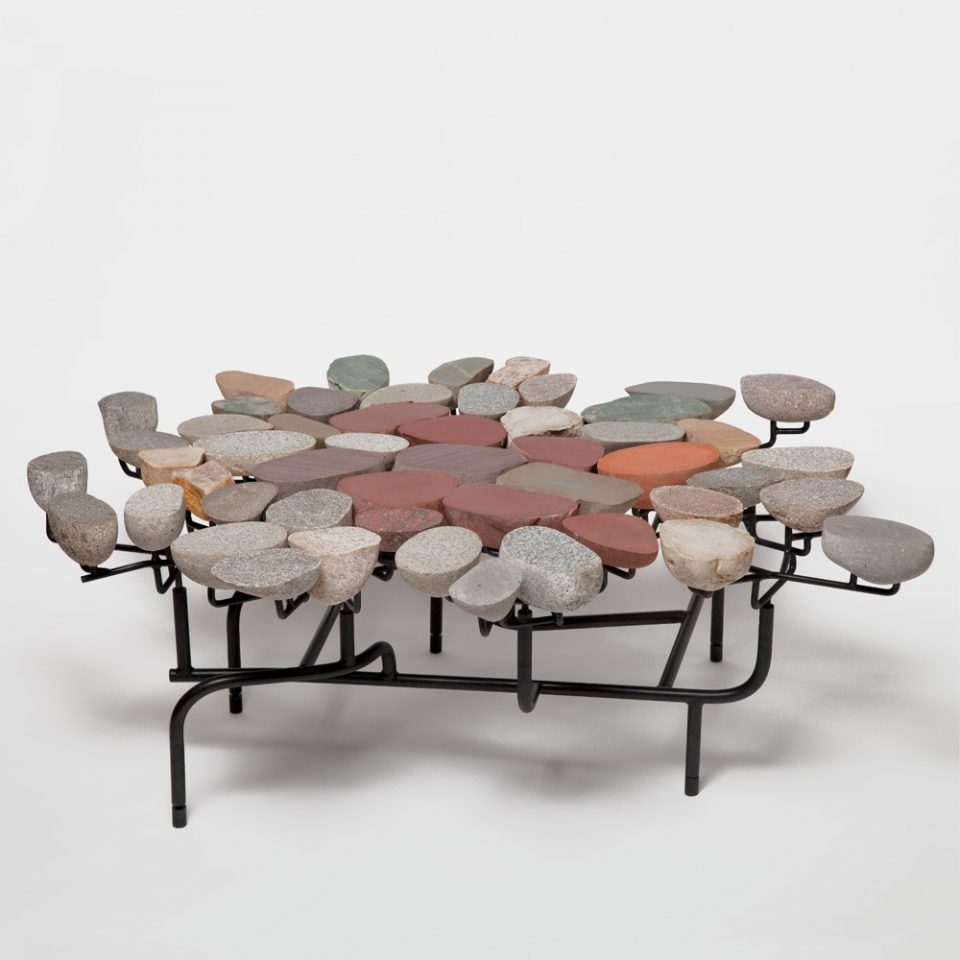 A table comprised of pebbles and black steel