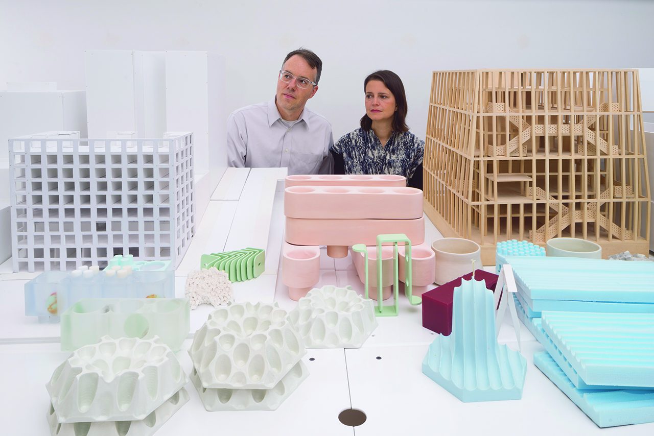 photo of a man and women behind a series of architectural models