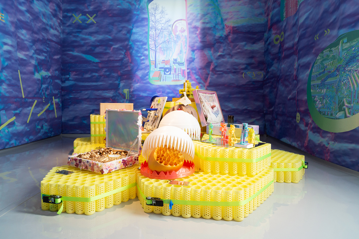 Photo of yellow plastic pedestals supporting small plastic objects in a room with blue-purple walls