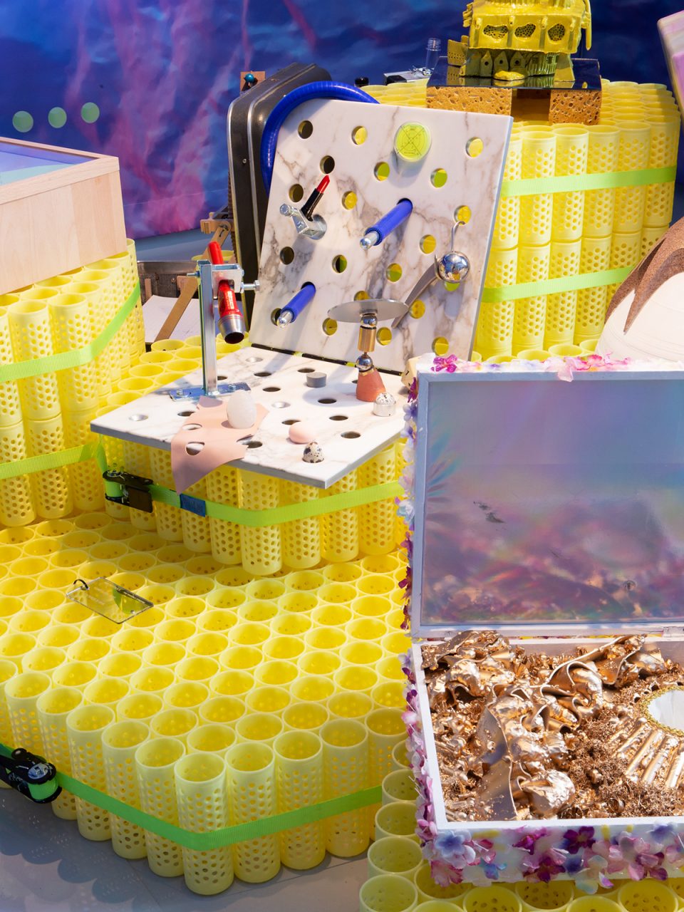 Photo of yellow plastic pedestals supporting displays with many little objects