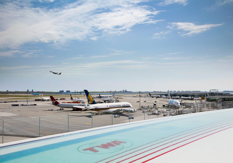 Photo of infinity pool that overlooks airplanes on tarmac at JFK