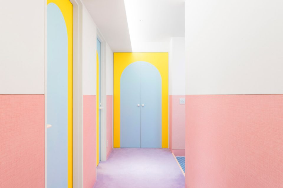 A pink hallway with yellow doors