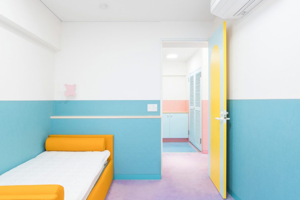 A bedroom with orange bed and blue walls