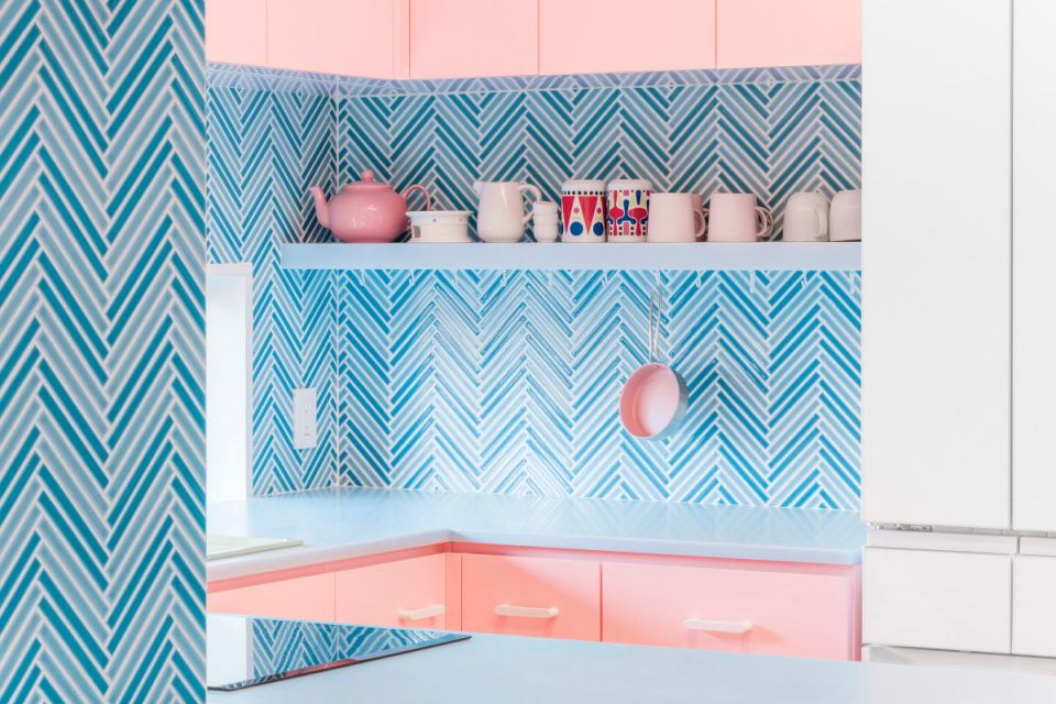 A pink kitchen with a blue backsplash