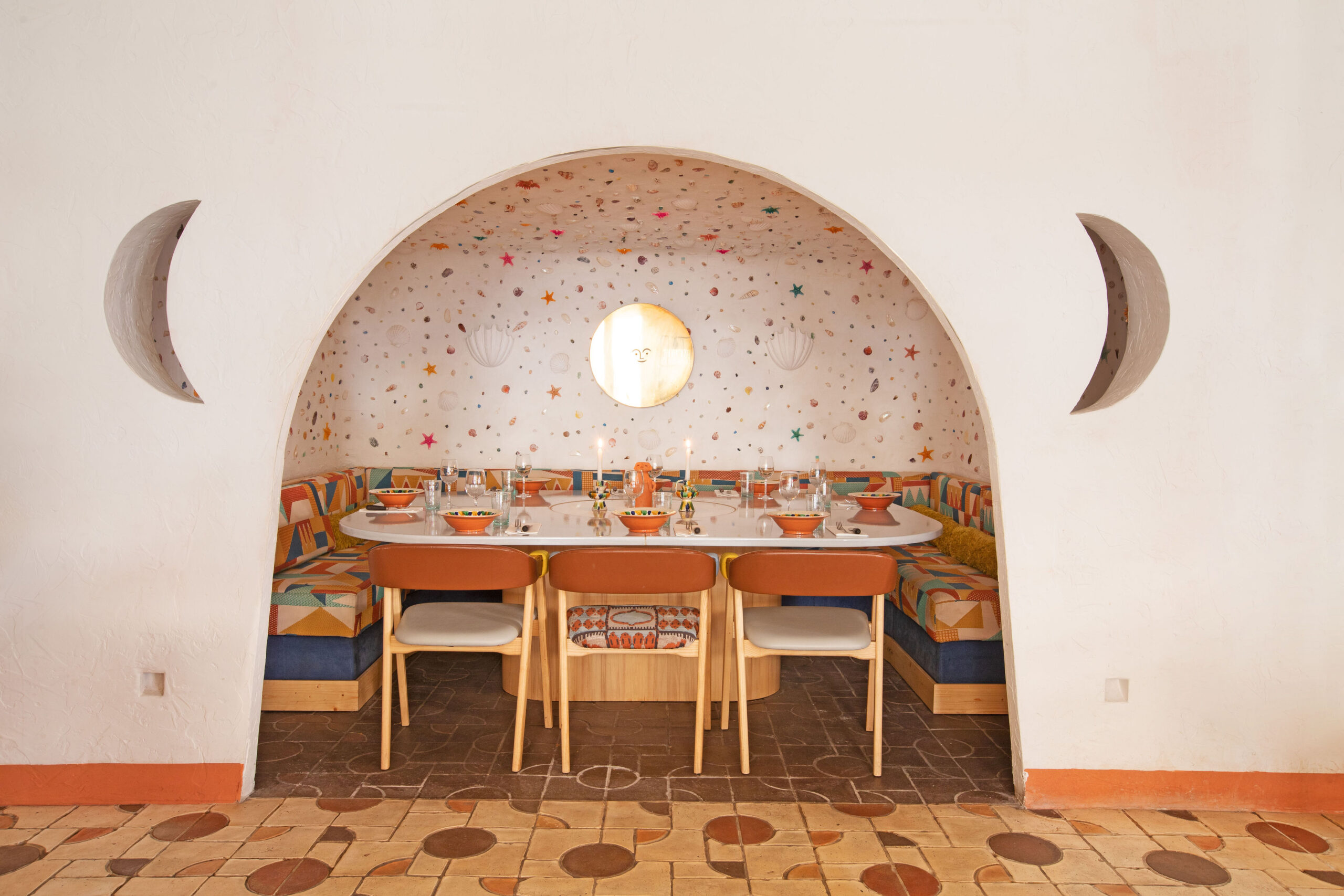 A portal to a restaurant booth, decked in stars, shells, and warm tones