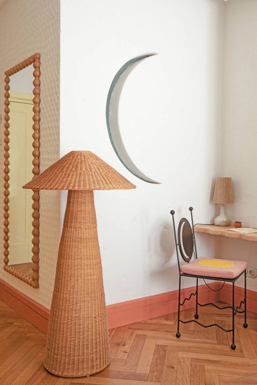 A crescent moon hangs on the wall in a bedroom