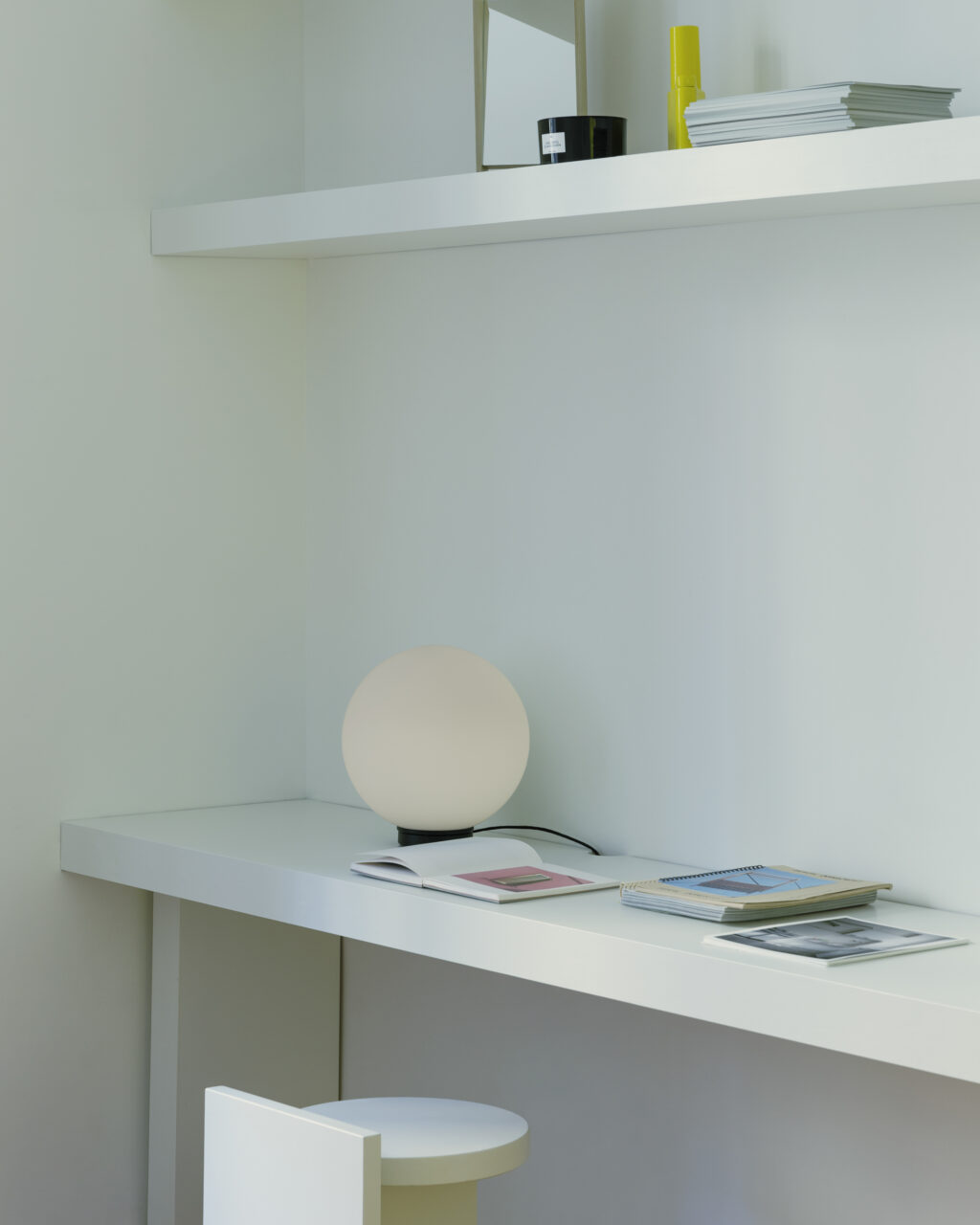 A desk and shelf in a white room