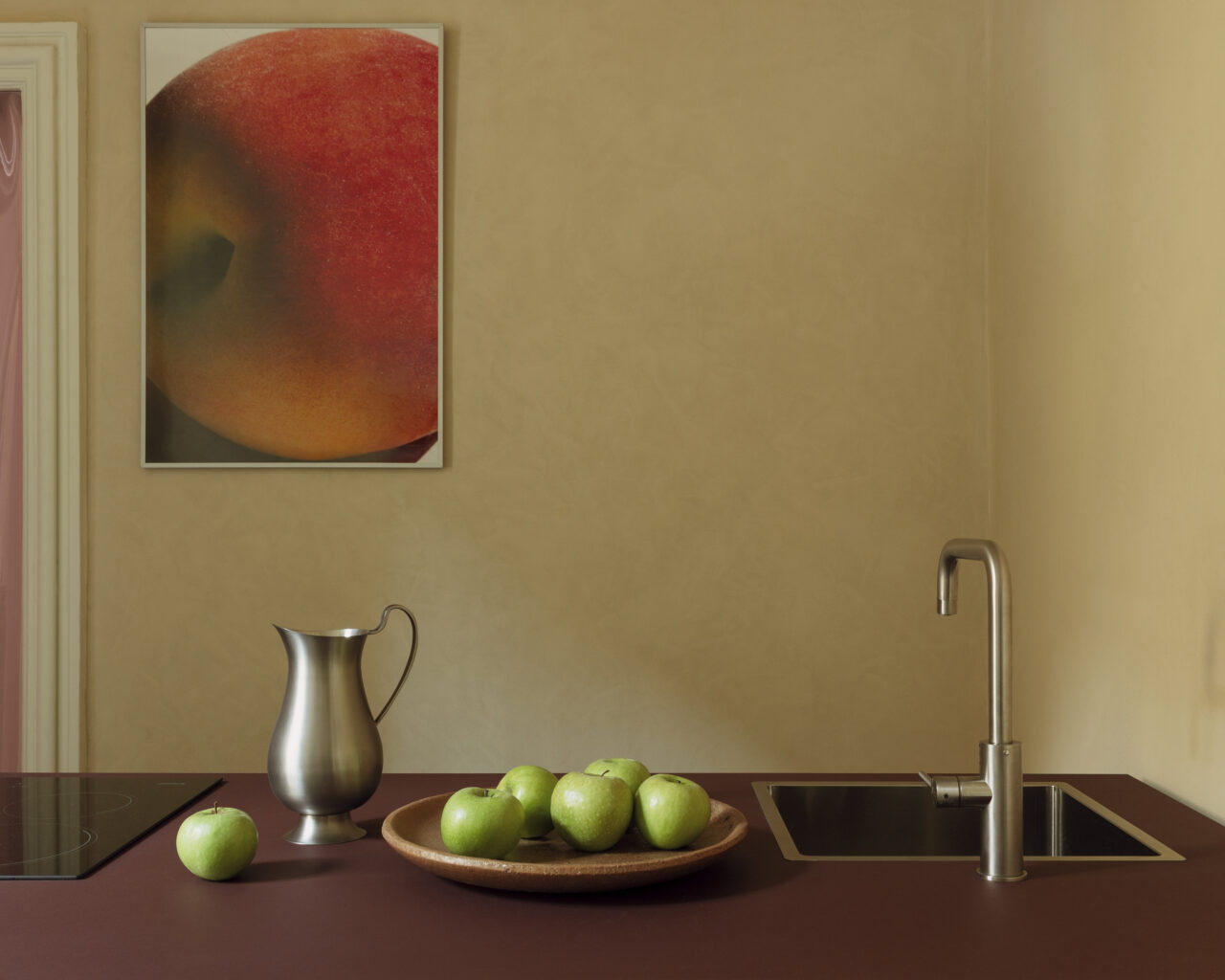 A warm-toned kitchen with fruit on the counter