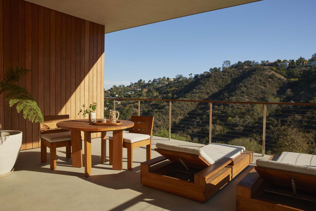 A view of the mountains is seen from a wood and concrete patio