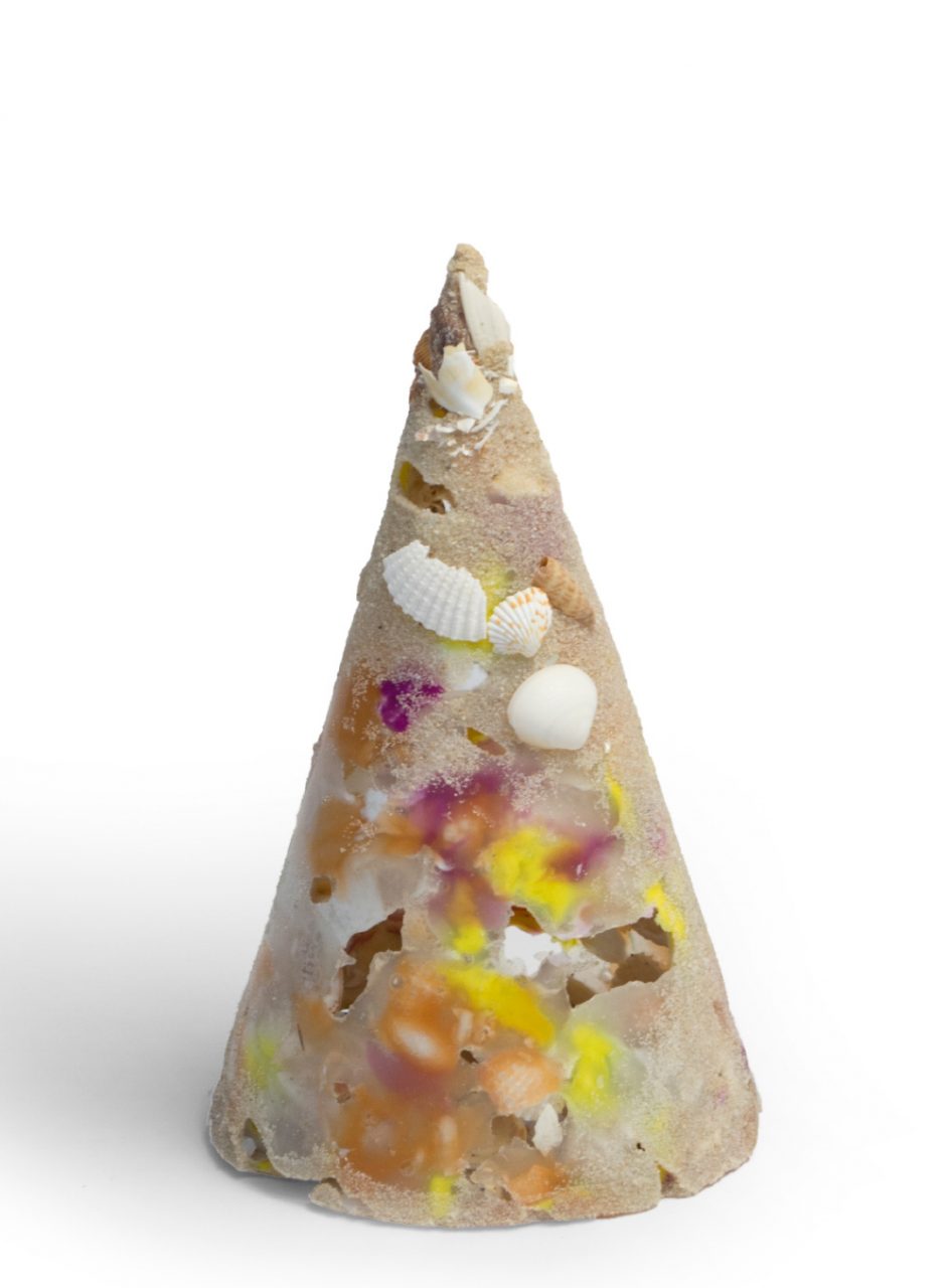 A cone comprised of sand, plastic, and shells