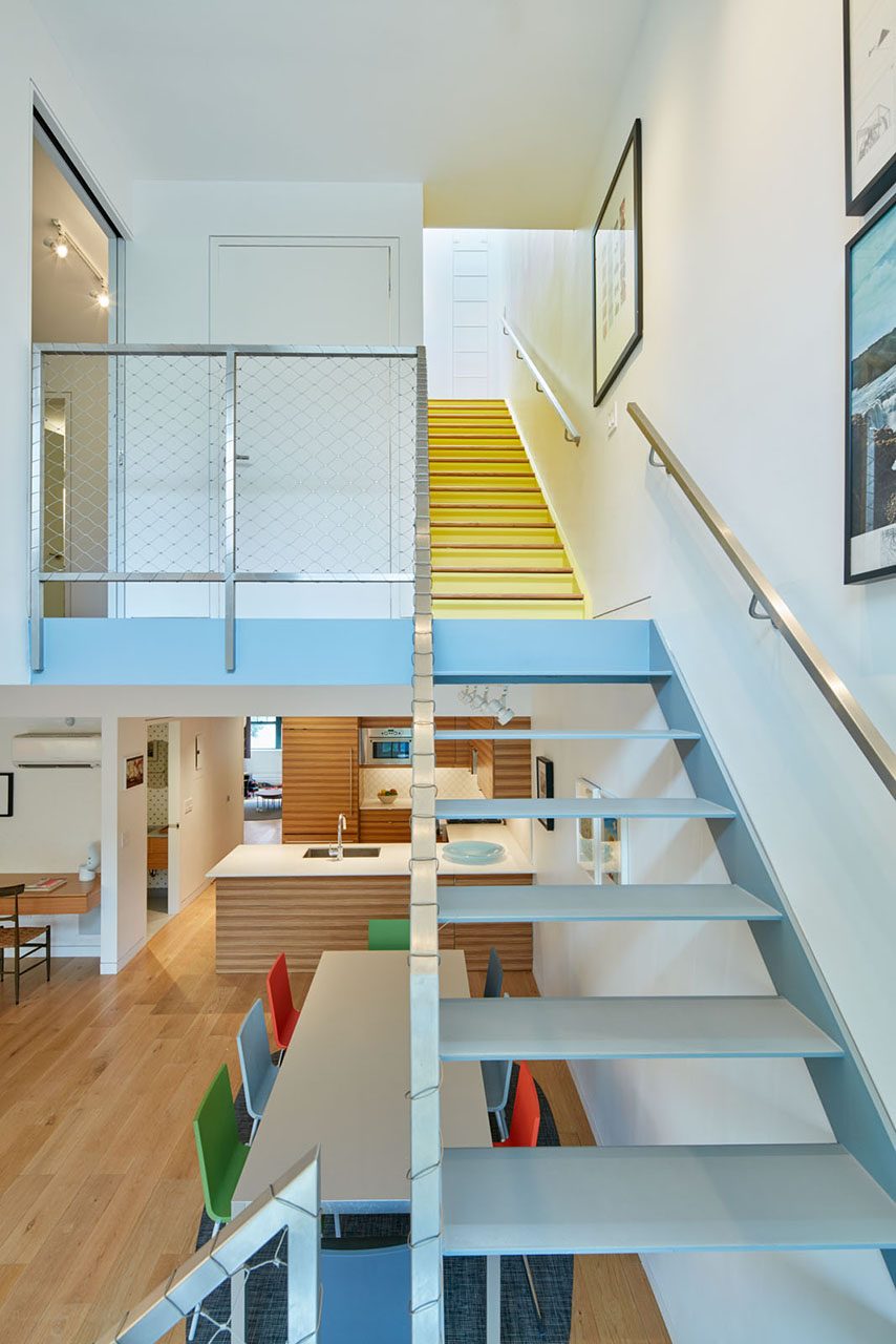 photo of a staircase in an apartment with a dinning room and kitchen in foreground