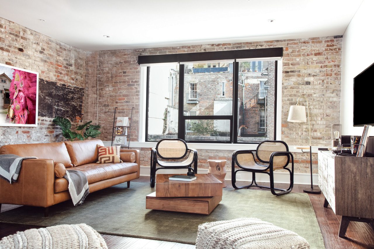A living room with brick walls and rattan chairs