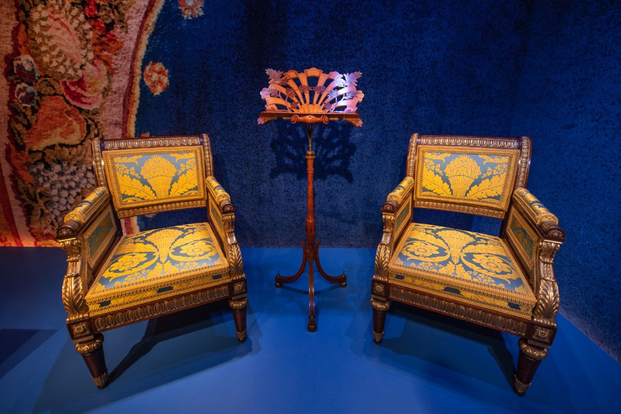 A set of yellow and blue armchairs against blue fabric