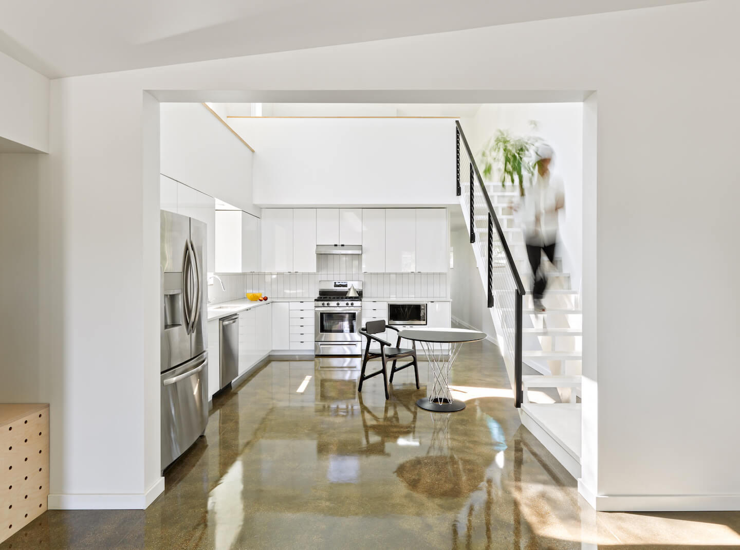 interior view of an open contemporary living area and kitchen with bright white walls