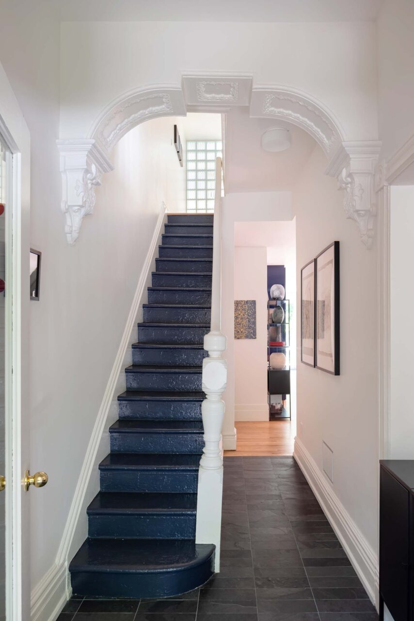 A blue staircase preserves the Victorian heritage of the home