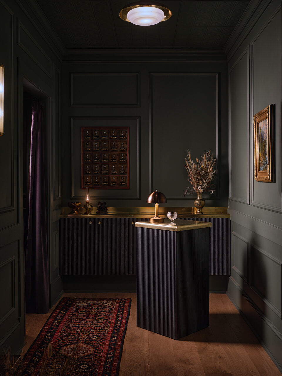 A dark hallway with a small check-in podium greets guests at Lone Mountain Ranch