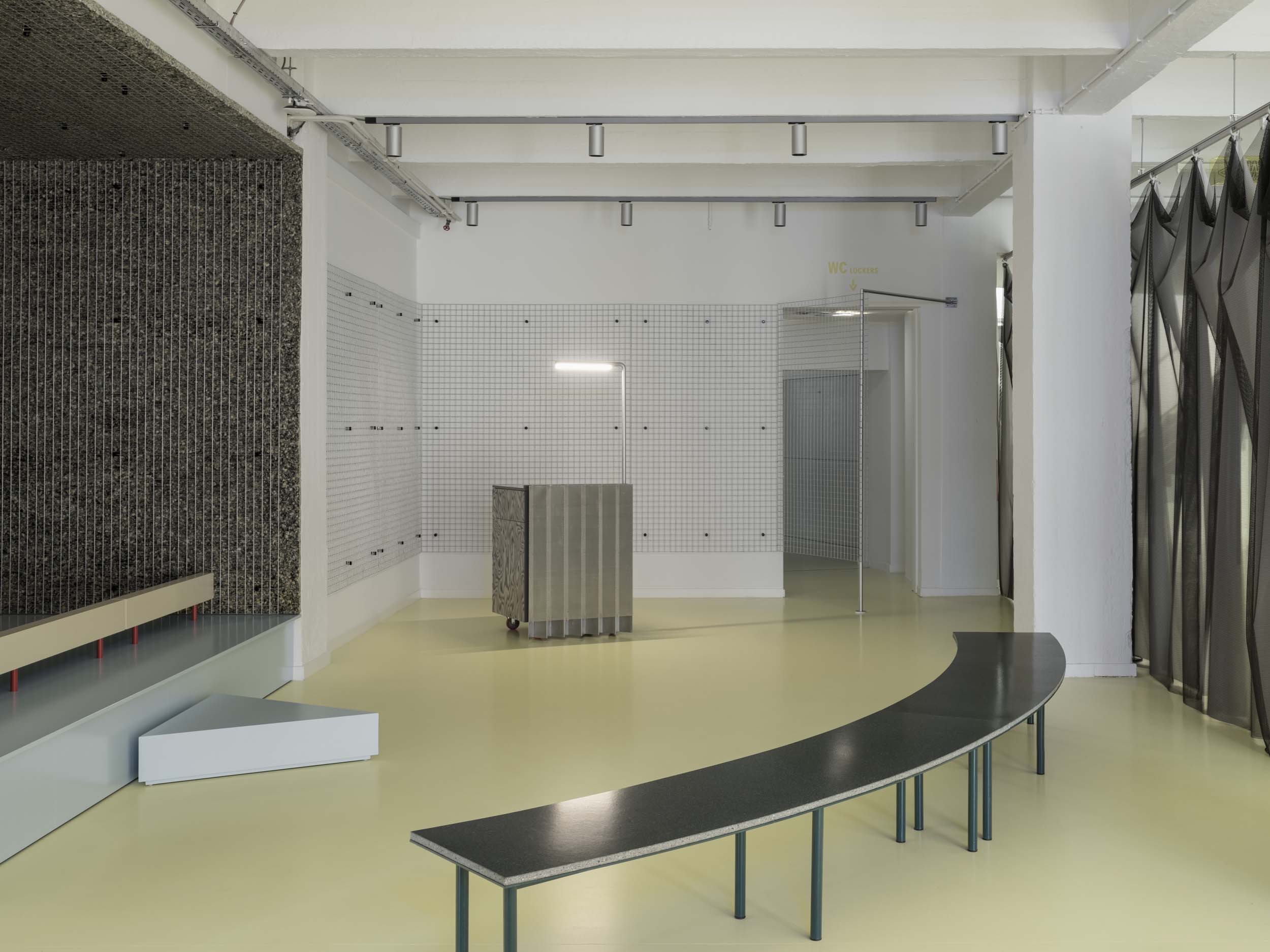 Yellow flooring unites a curved bench and other designs at FOMU