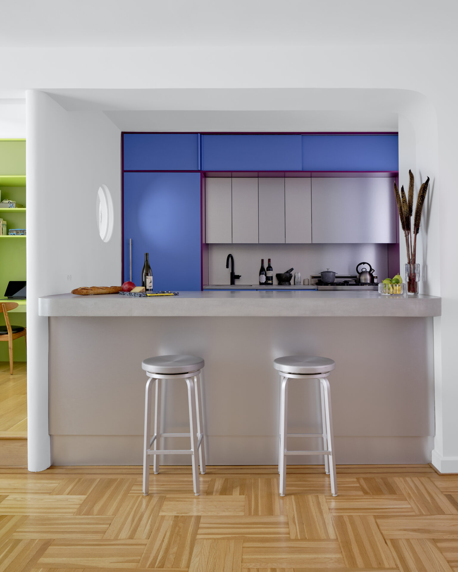 An aluminum kitchen features a bright blue backsplash by Ideas of Order