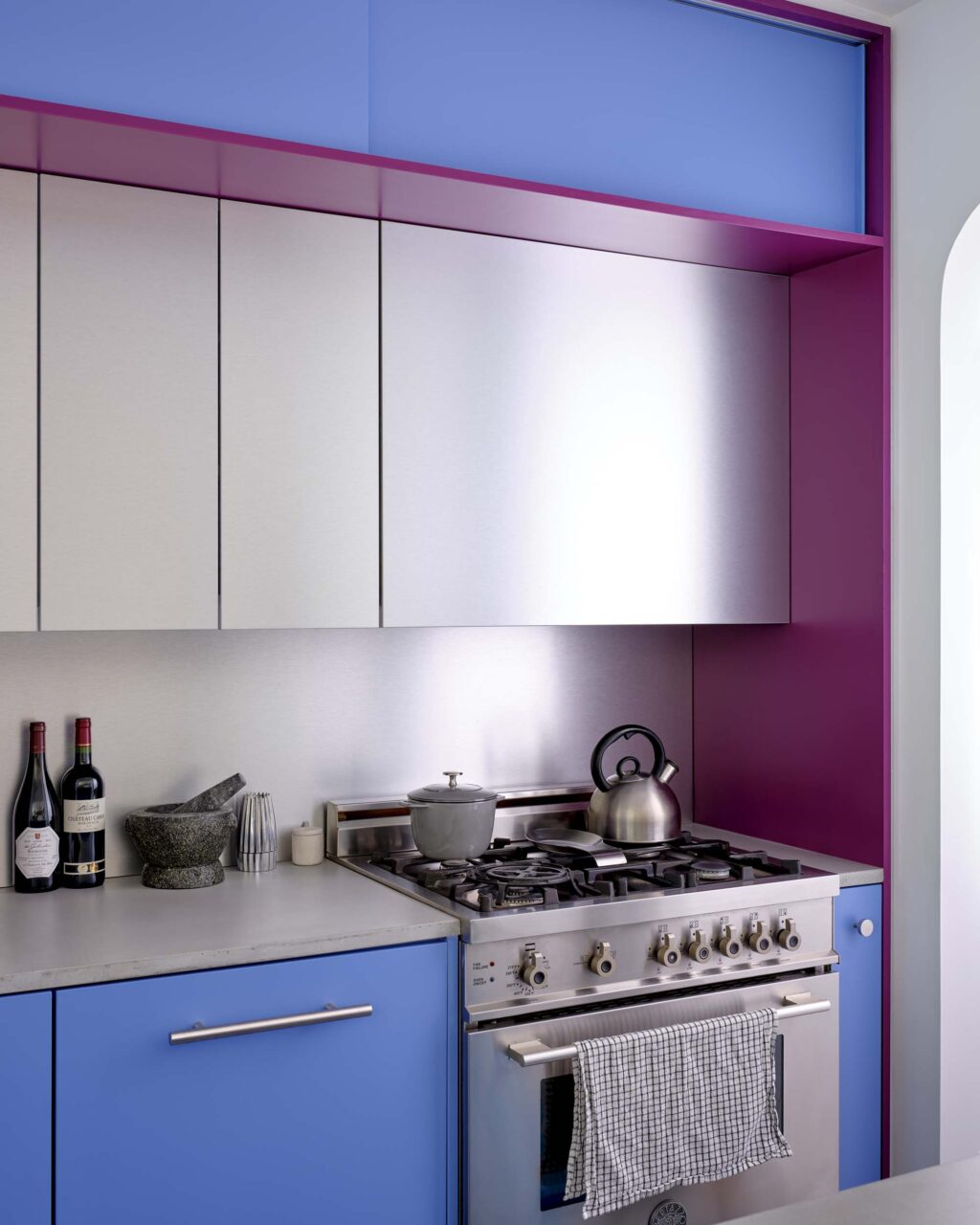 A kitchen with blue and purple paneling and aluminum cabinets