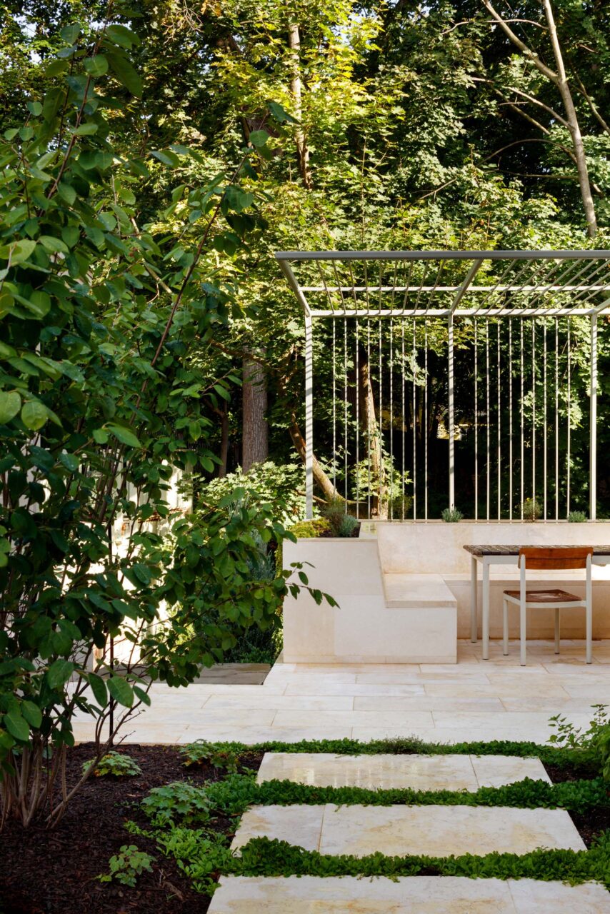 Stone steps lead to a terrace surrounded by greenery at Cleveland Park House
