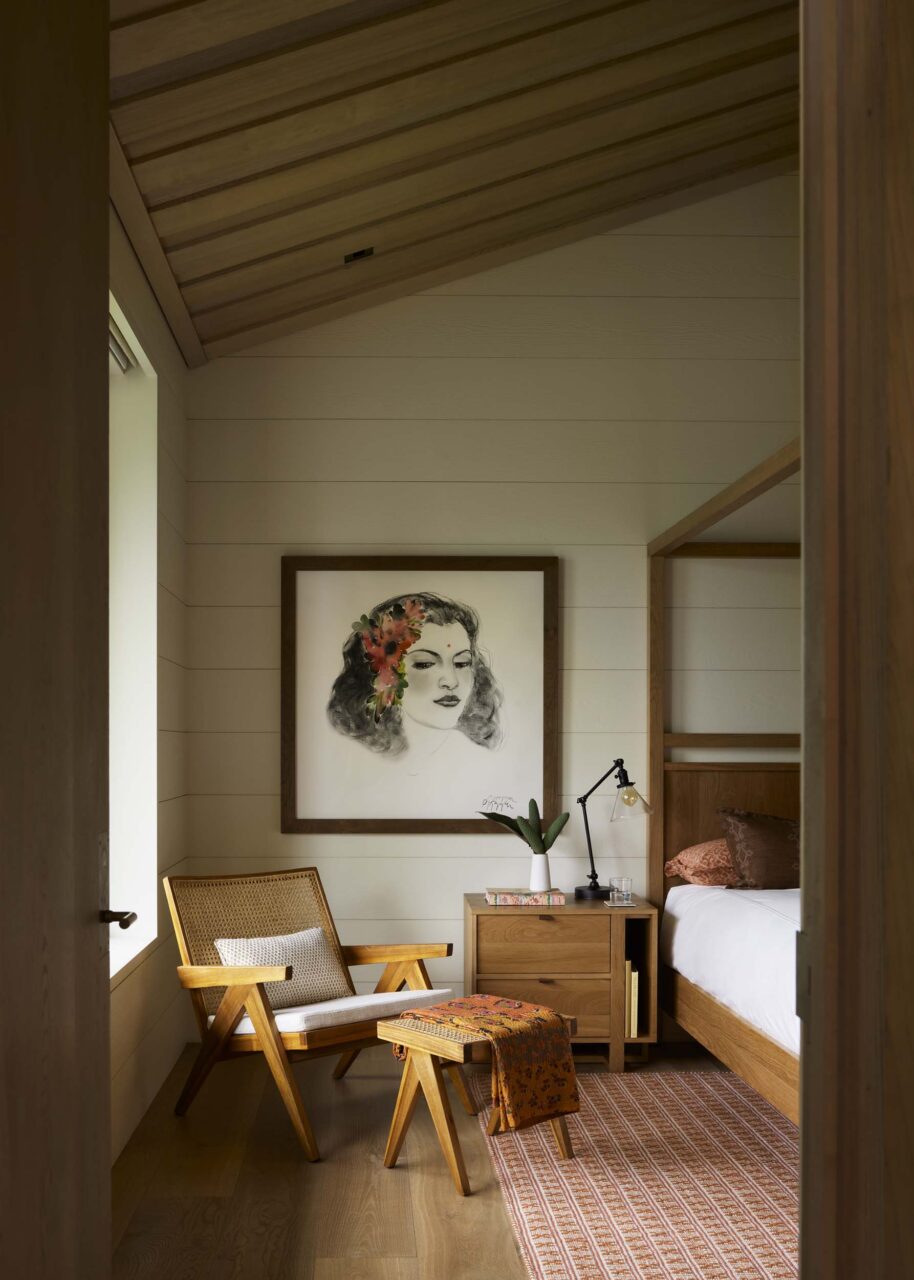 A lounge chair sits in a bedroom at Hale Kiawe by Walker Warner