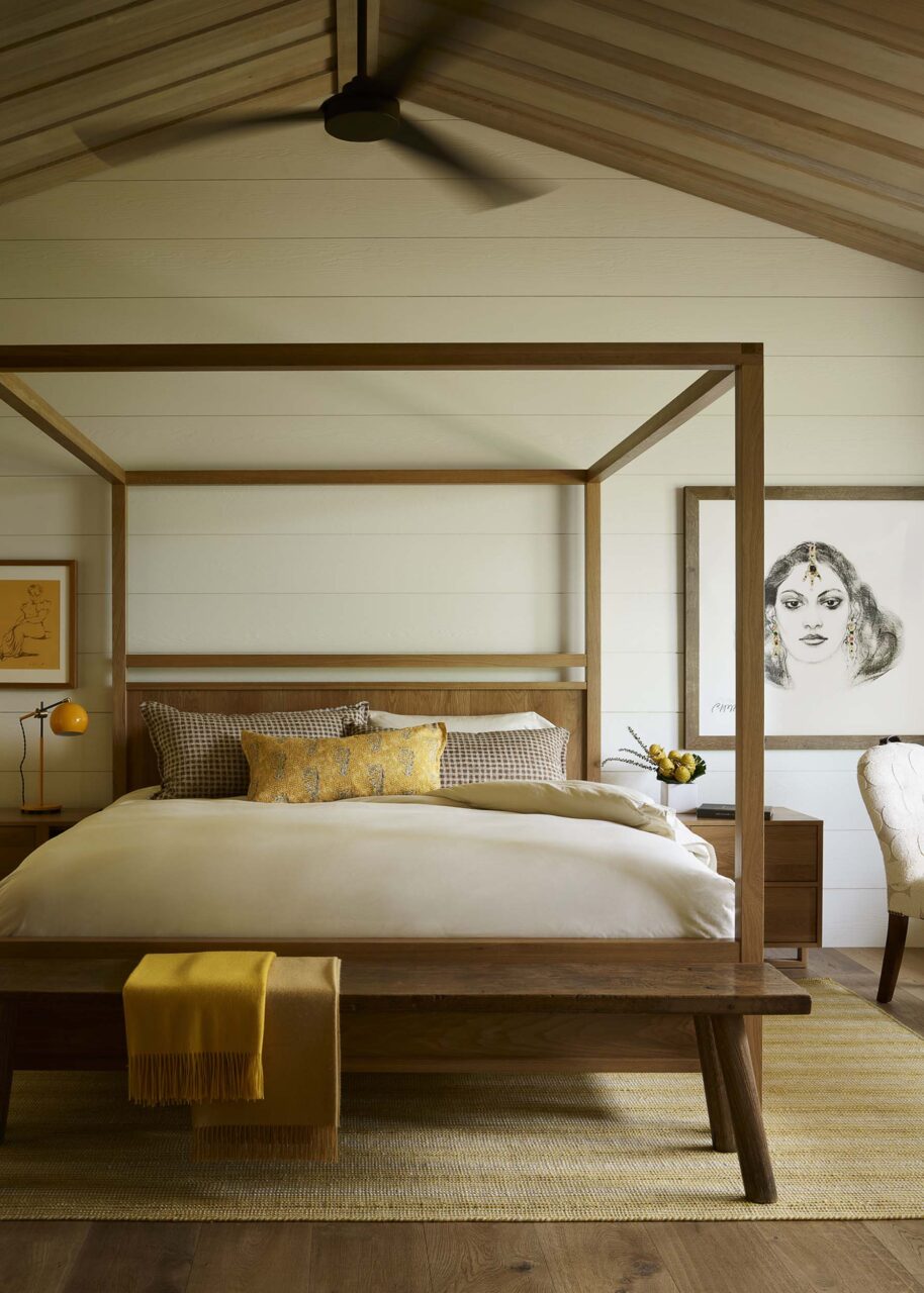A wooden bed sits under a gabled roof designed by Walker Warner