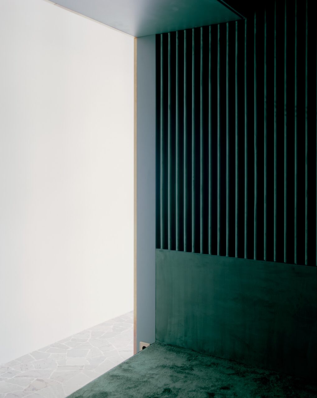 Fluted green walls meets a plush carpet of the same color in the Golden Box apartment
