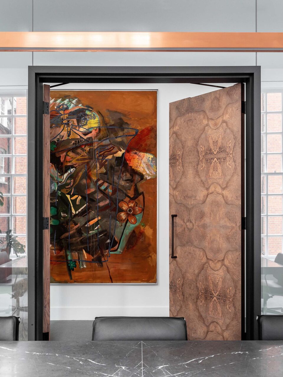 A conference room in London features burl walnut doors