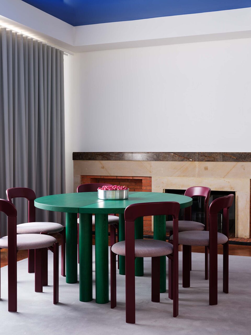 A green dining table sits under a blue ceiling