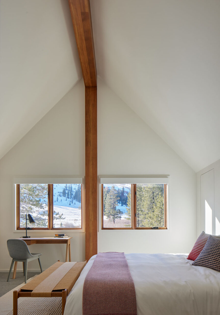 A white bedroom with angled ceilings at Pennyroyal house