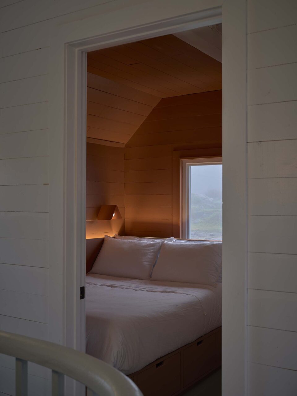 An orange-hued bedroom can be glimpsed from an open door at Burdens Point