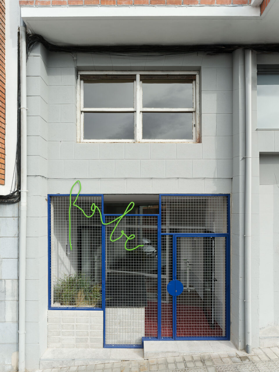 A photo of BeAr Architects’s RABE studio with a blue metal mesh facade