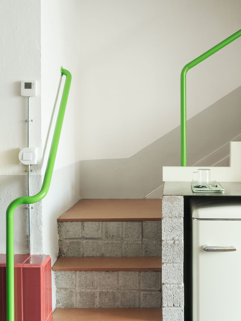An electric green railing leads upstairs at RABE