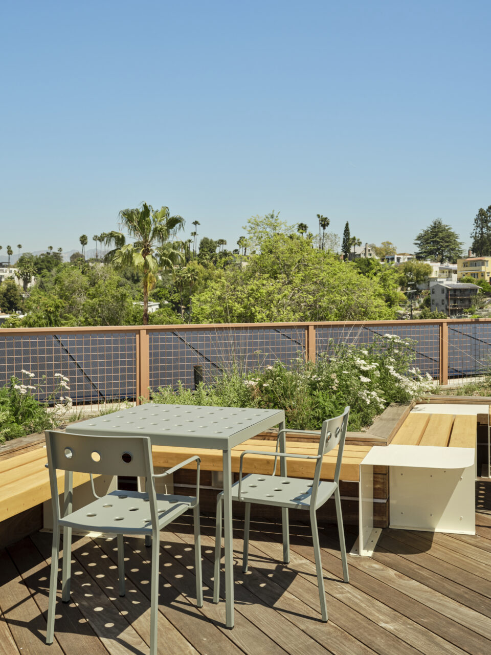 An outdoor area with a wooden bench and tables and chairs for SuperBungalow