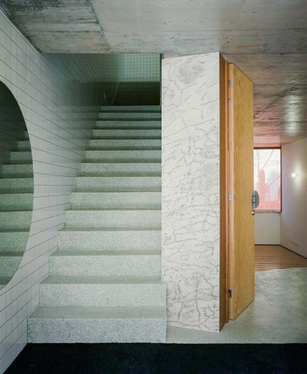 A stairwell and crescent mirror in 102 by Fala Atelier