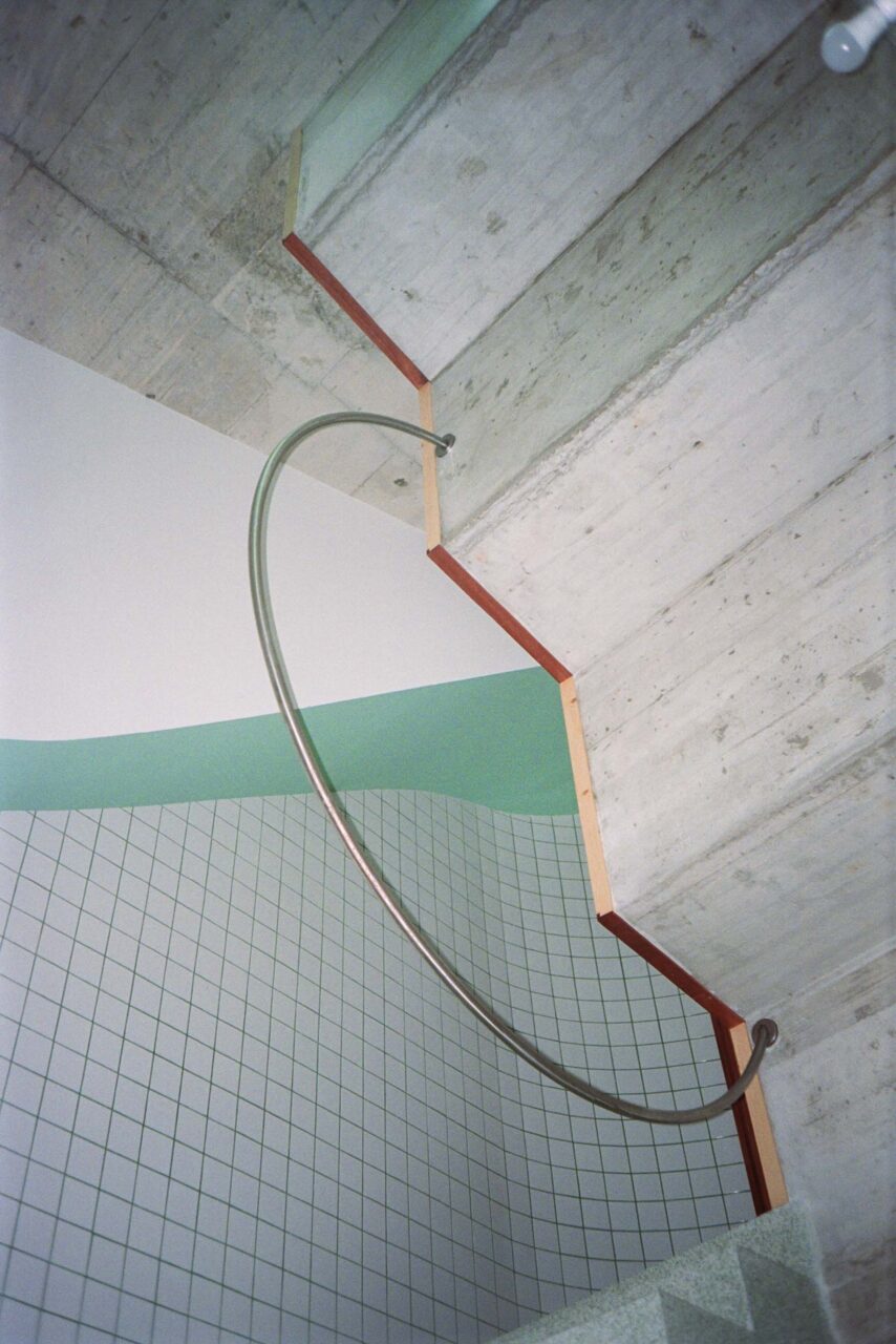 A circular handrail hangs off of steps in project 102