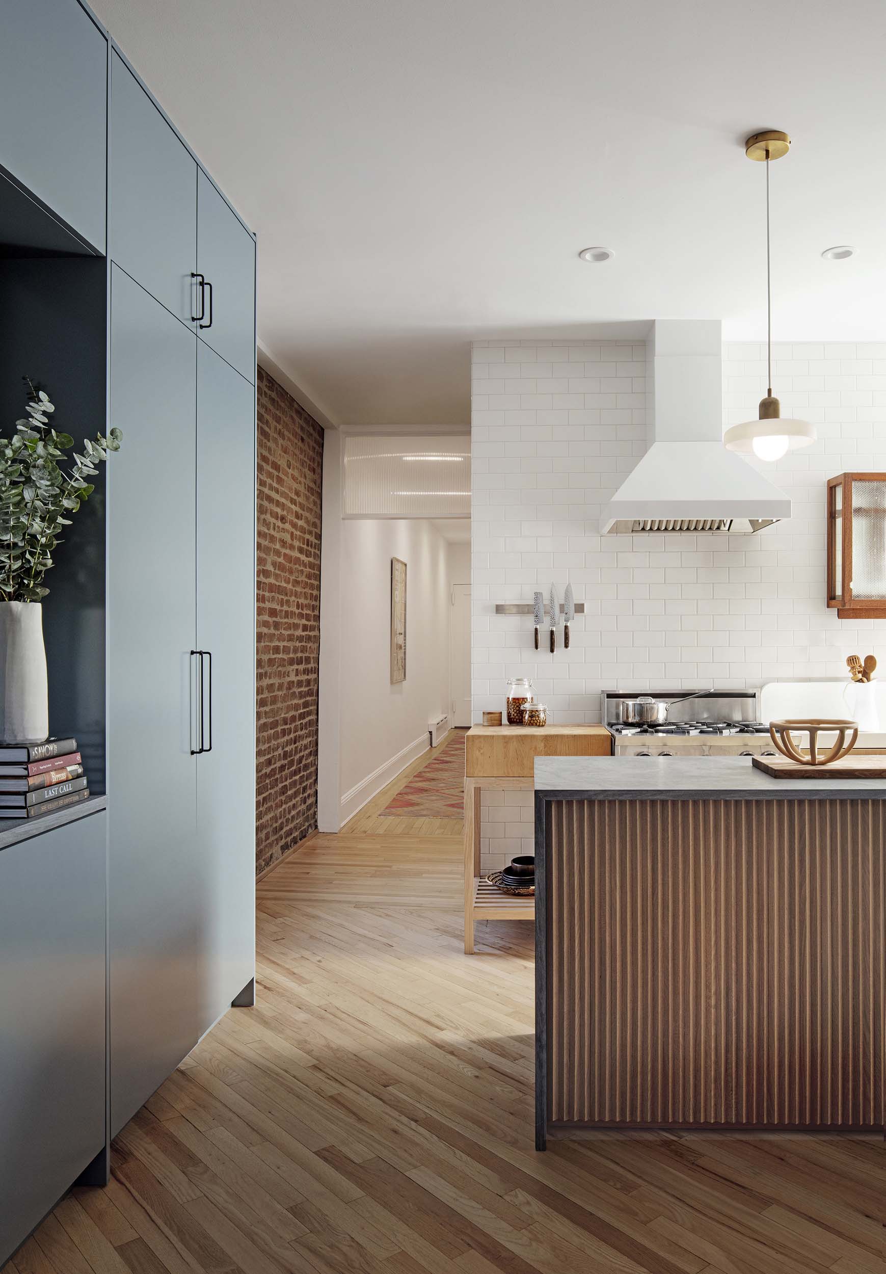 A kitchen with blue millwork by Kalos Eidos