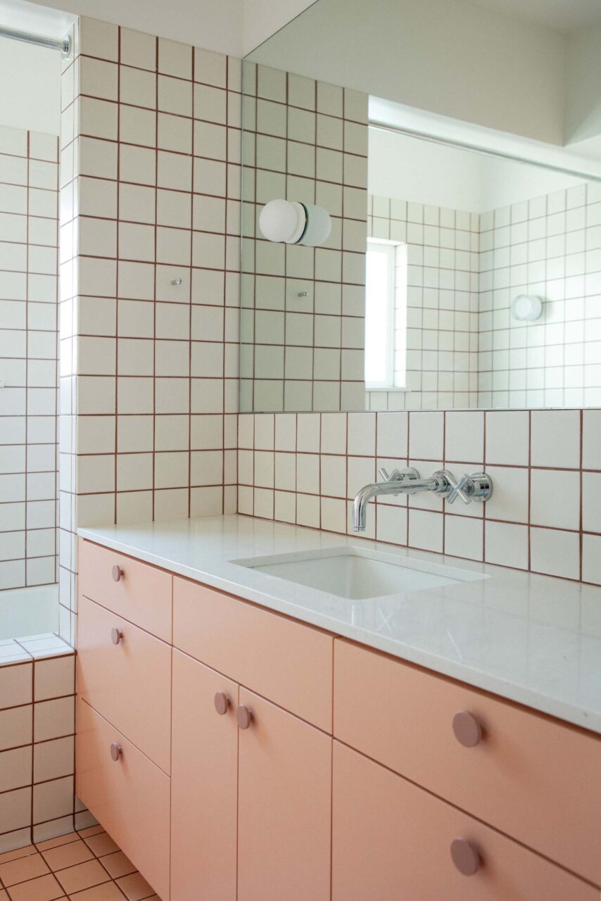 A white and pink bathroom clad in tiles designed by Loaf