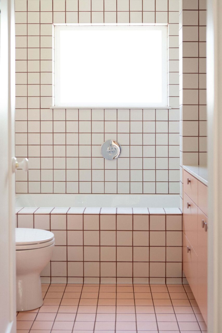 Tiles frame an enlarged window of a bathroom by Loaf