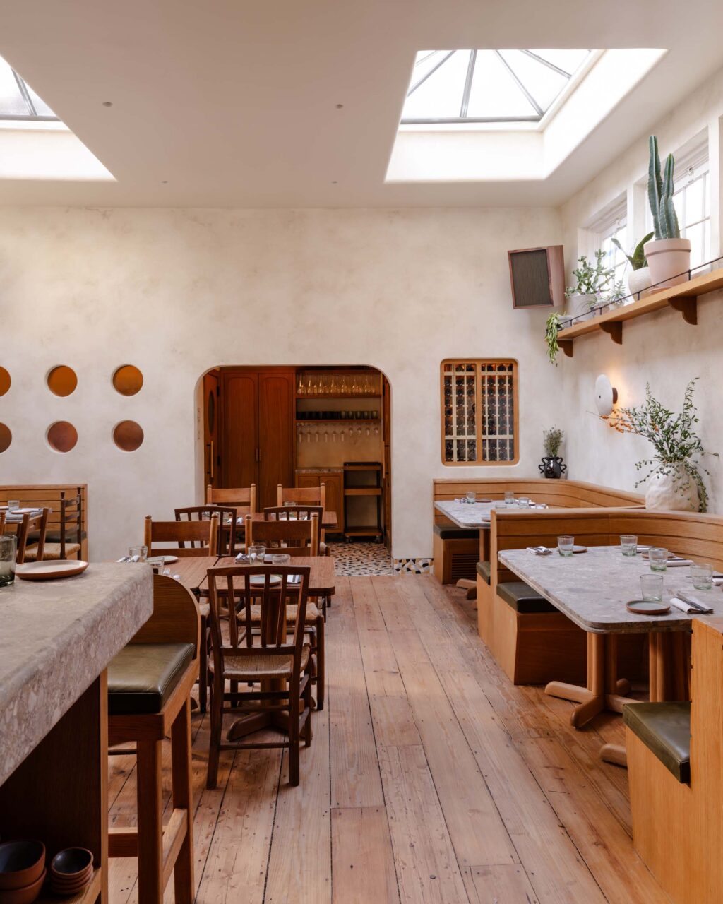 The back dining room at Theodora features skylights and ceramic wall sconces