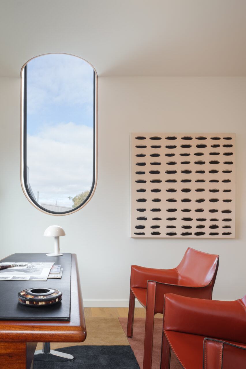 An office is decorated with a window and red chairs in an offset ADU