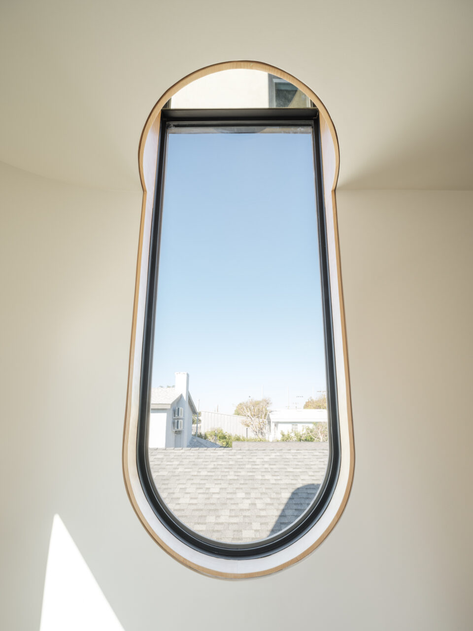 A slender window is topped with a mirror designed by Byben