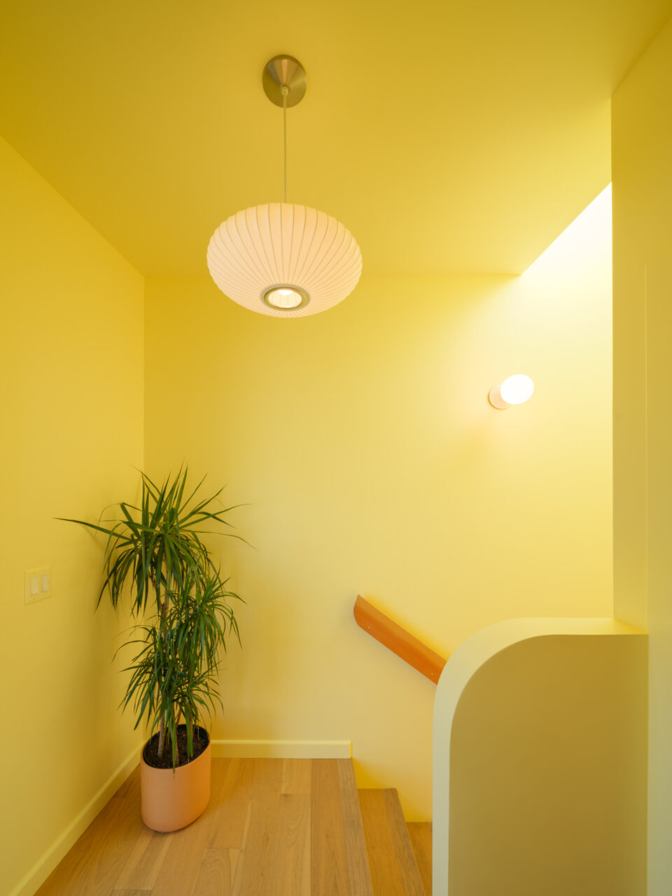 A yellow staircase at the top of the stairs features a pendant light