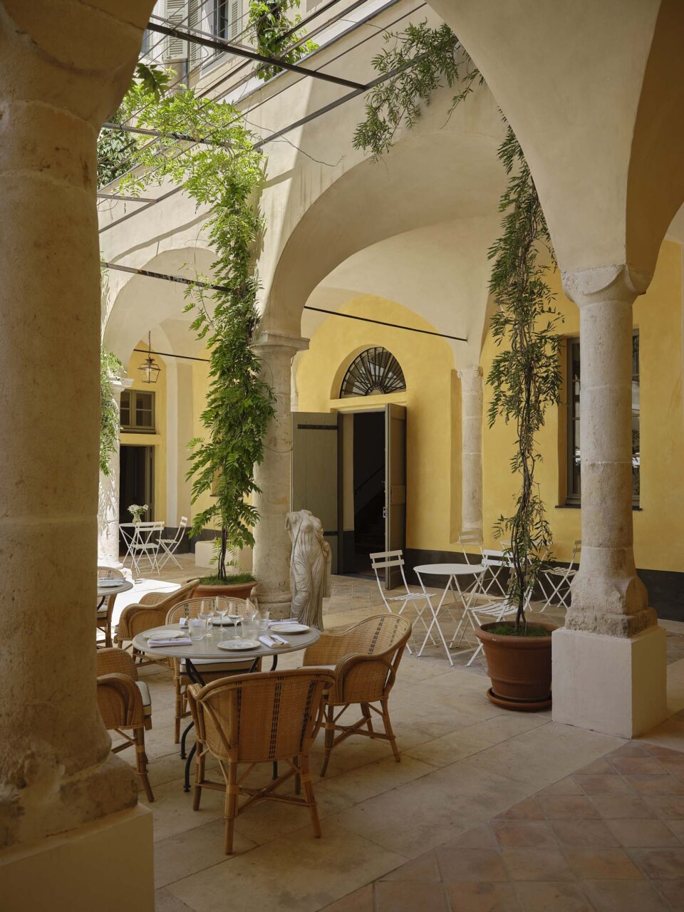 A courtyard with yellow walls at Hotel du Couvent