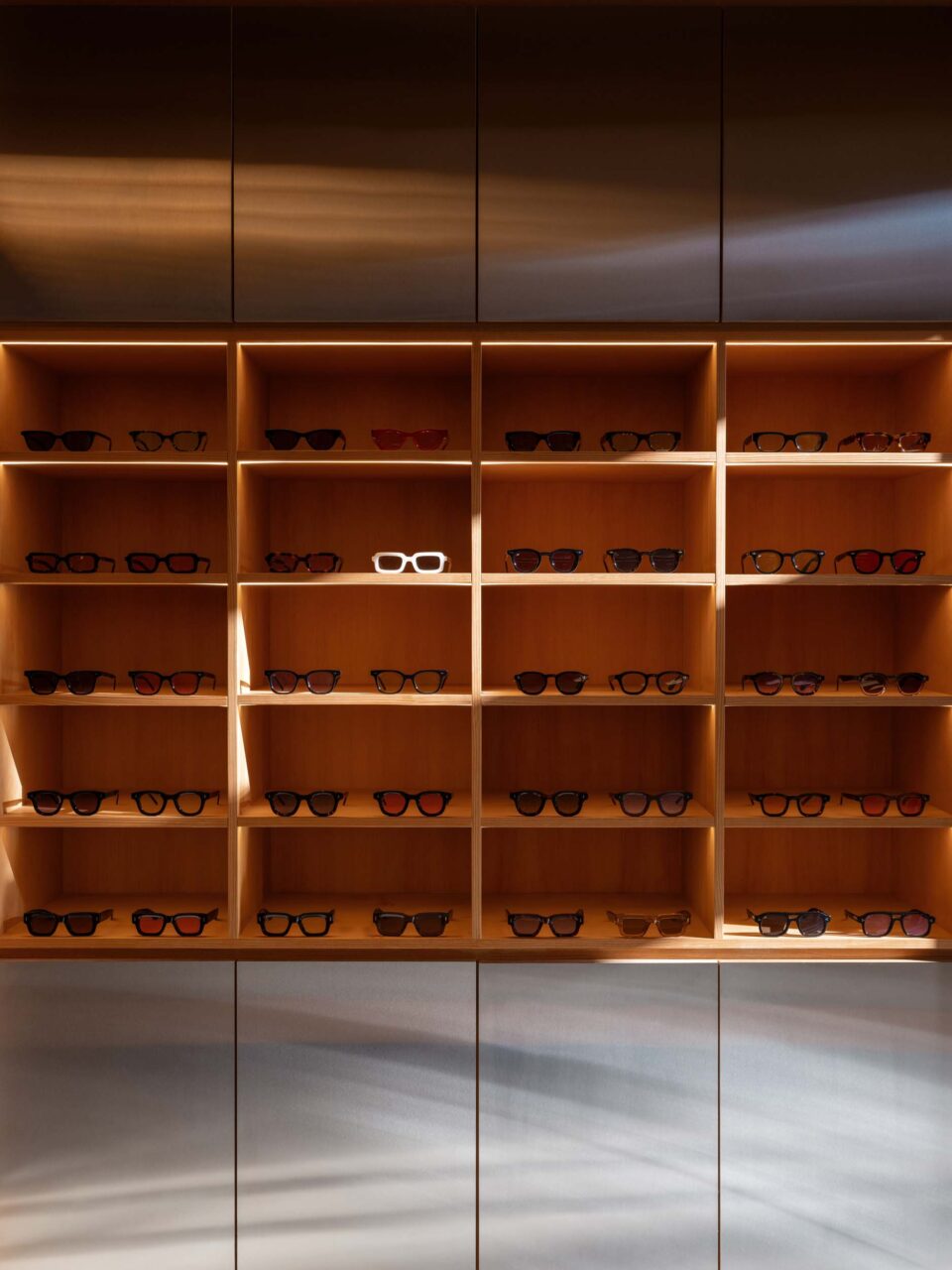 a wood shelf lined with eyeglasses