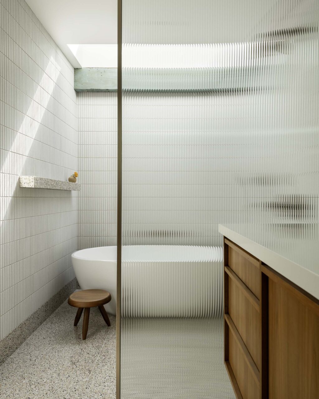 A white tiled bathroom with a new skylight inserted by Cover Architecture