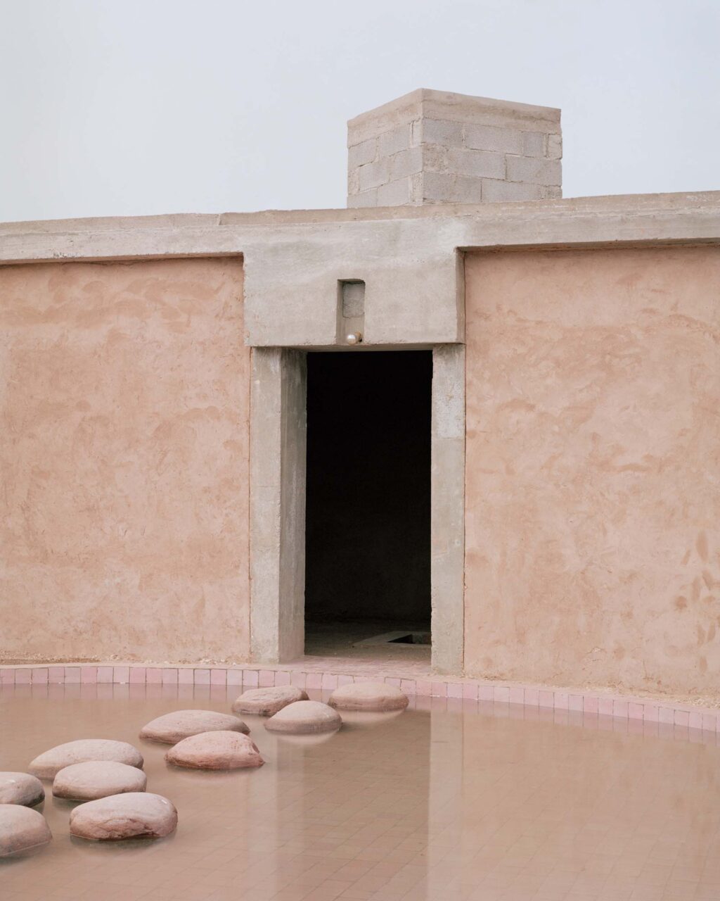 A pond leads to the entrance of Dar El Farina