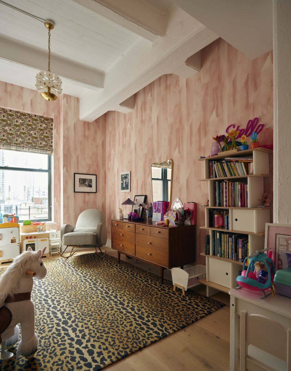 pink wallpaper in kid's bedroom with an animal print rug