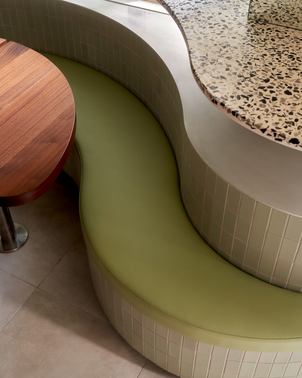 curving banquettes in green tiles